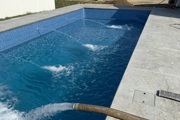 Water being pumped into a swimming pool during a water delivery service in St. Clair County, IL